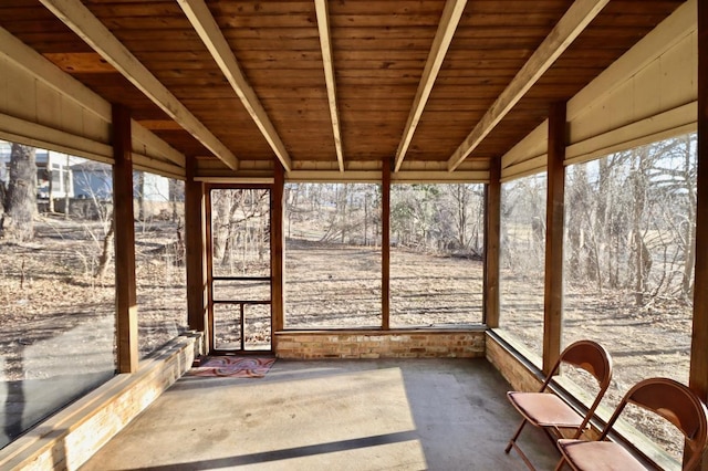 unfurnished sunroom with beam ceiling