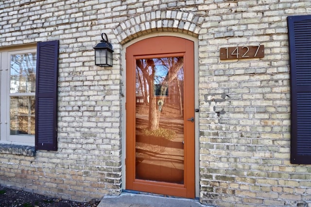 view of exterior entry with brick siding