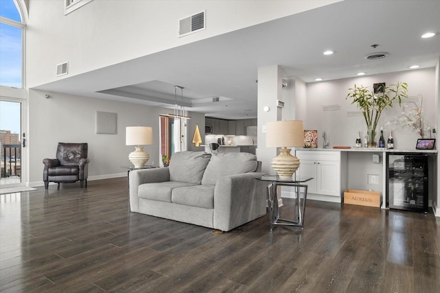 living area featuring visible vents, wine cooler, baseboards, and dark wood-style floors