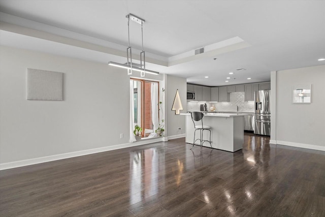 unfurnished living room with visible vents, recessed lighting, baseboards, and dark wood-style flooring