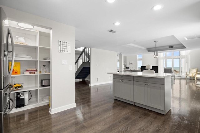 kitchen with visible vents, a kitchen island, dark wood finished floors, gray cabinetry, and open floor plan