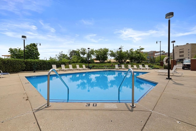 pool with a patio and fence