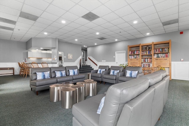 carpeted living room with recessed lighting, wainscoting, and a drop ceiling