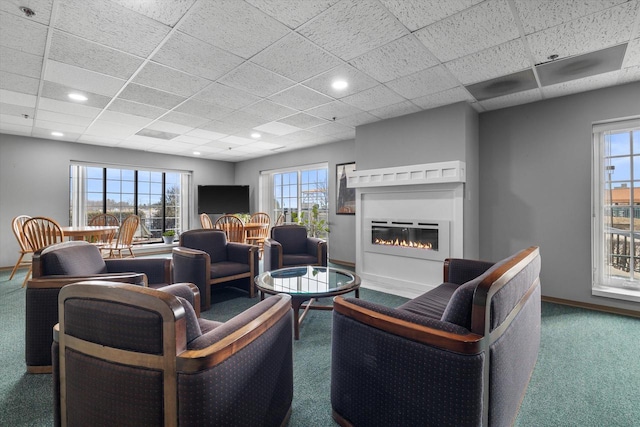 carpeted living room featuring a glass covered fireplace, recessed lighting, a paneled ceiling, and baseboards