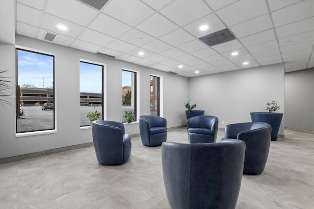 living room featuring a drop ceiling, recessed lighting, and visible vents