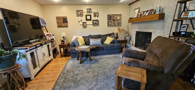 living room with a brick fireplace and light wood-type flooring