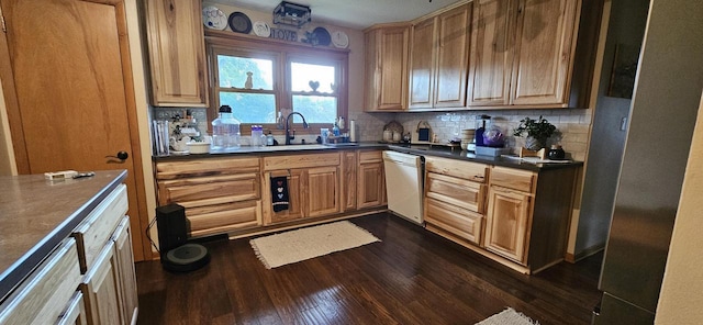 kitchen featuring dark wood-type flooring, a sink, dark countertops, backsplash, and dishwasher