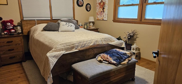 bedroom with wood finished floors and baseboards