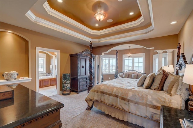 bedroom with a tray ceiling, arched walkways, light carpet, and decorative columns