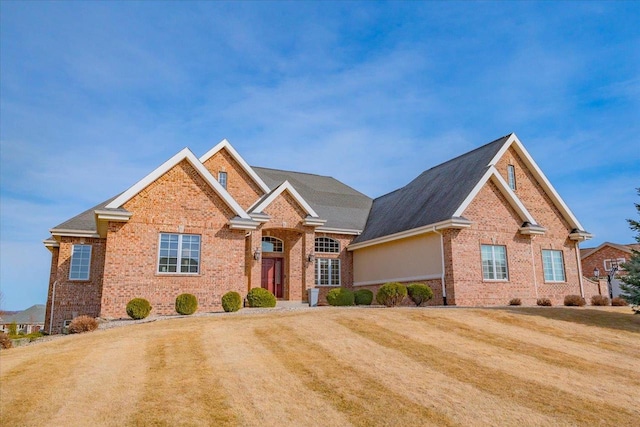 view of front of house with a front yard and brick siding