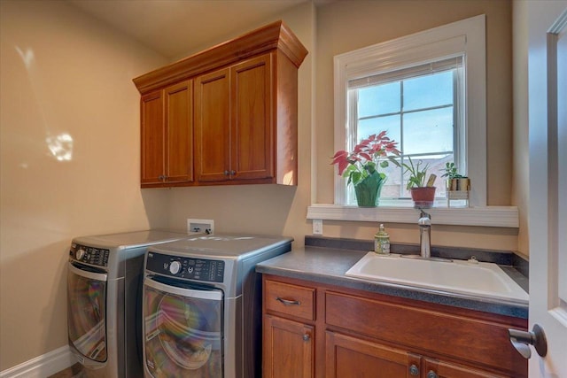 washroom with cabinet space, independent washer and dryer, and a sink