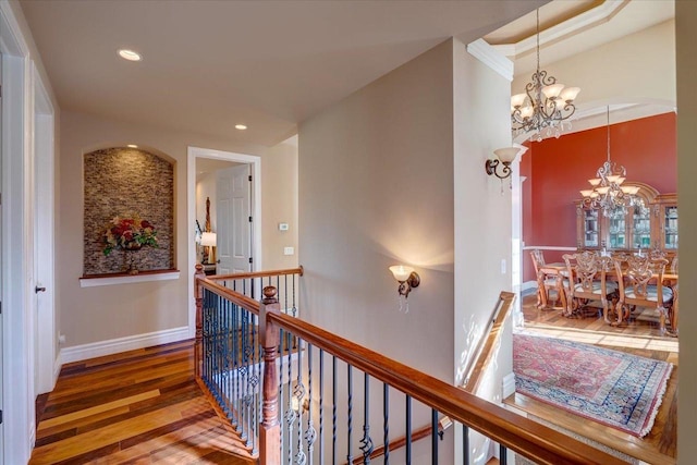 corridor with baseboards, a chandelier, an upstairs landing, recessed lighting, and wood finished floors