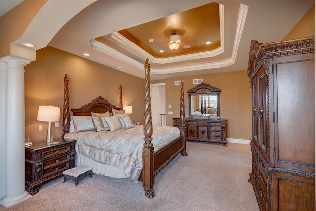 carpeted bedroom featuring ornate columns, visible vents, a tray ceiling, and ornamental molding