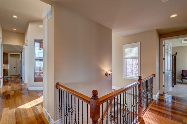 hallway featuring an upstairs landing, recessed lighting, baseboards, and wood finished floors