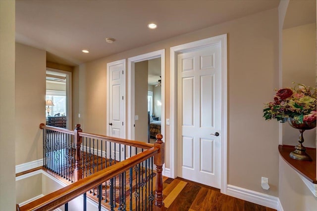 hall with recessed lighting, baseboards, an upstairs landing, and wood finished floors