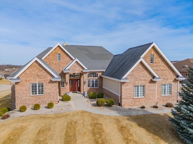 traditional-style house featuring brick siding and a shingled roof