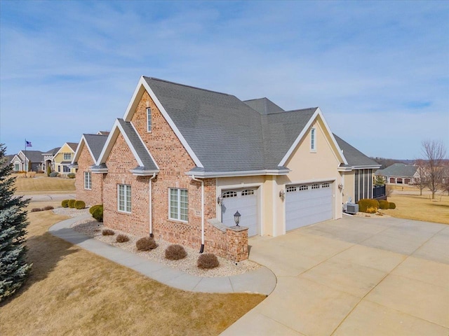 traditional-style house featuring brick siding, central air condition unit, concrete driveway, a front yard, and a garage