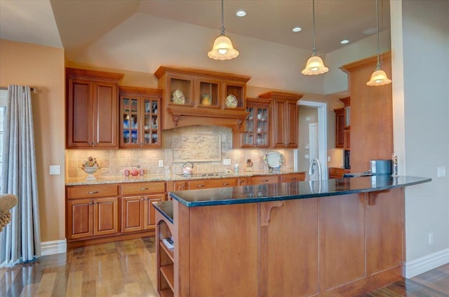 kitchen featuring light wood-style floors, brown cabinetry, and tasteful backsplash