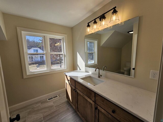 2 S 8th St, Bayfield, WI 54814 - bathroom with toilet, vanity, baseboards, wood tiled floor, and visible vents