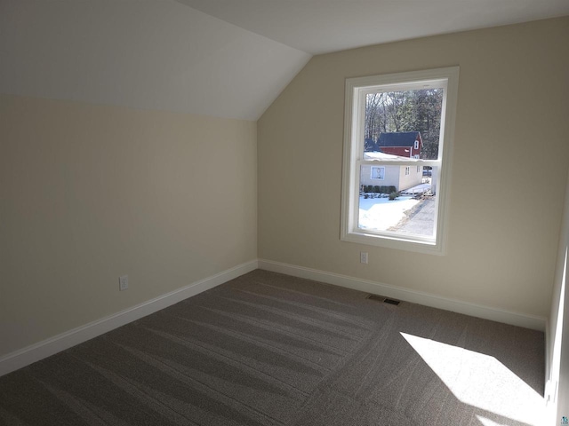 2 S 8th St, Bayfield, WI 54814 - additional living space with dark carpet, baseboards, vaulted ceiling, and visible vents