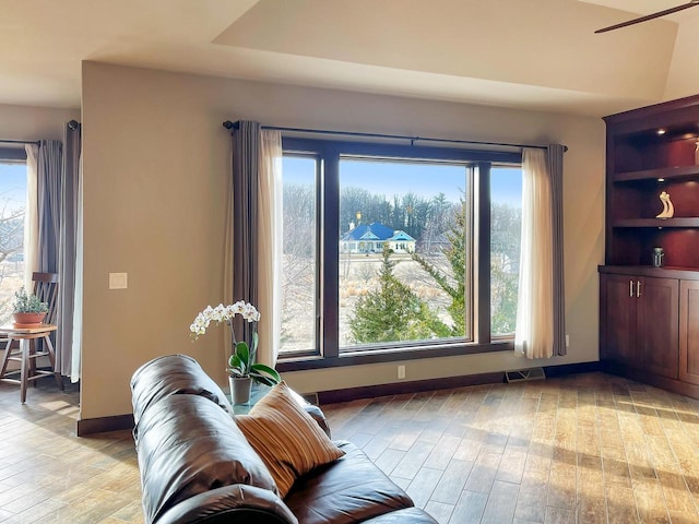 living area featuring a wealth of natural light, visible vents, baseboards, and light wood-style flooring