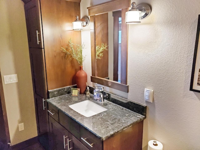 bathroom featuring vanity and a textured wall