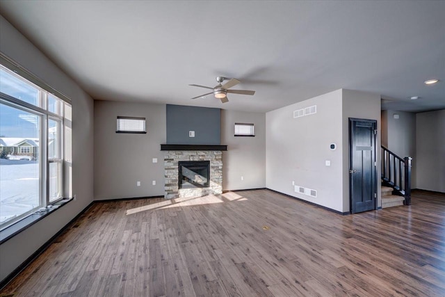 unfurnished living room with visible vents, baseboards, wood finished floors, and a ceiling fan