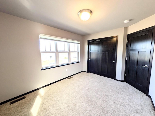 unfurnished bedroom with baseboards, visible vents, and a closet