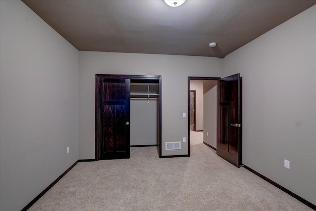 unfurnished bedroom featuring visible vents, baseboards, light colored carpet, and a closet