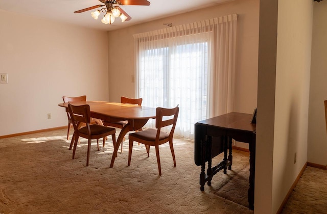 carpeted dining room featuring a ceiling fan, baseboards, and a wealth of natural light