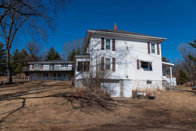 rear view of house with a garage and a chimney