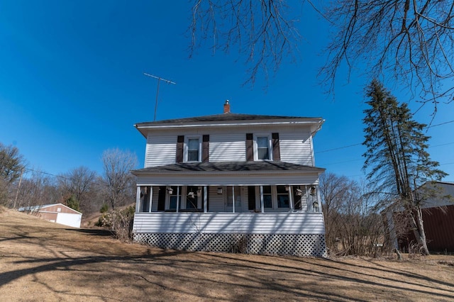 american foursquare style home featuring a porch and a front lawn