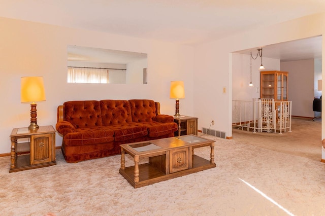 living area with visible vents, carpet floors, and baseboards