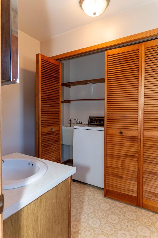 bathroom with vanity, washer / dryer, and a closet