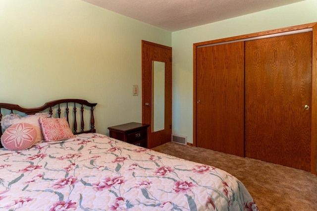 carpeted bedroom with a closet, visible vents, and a textured ceiling