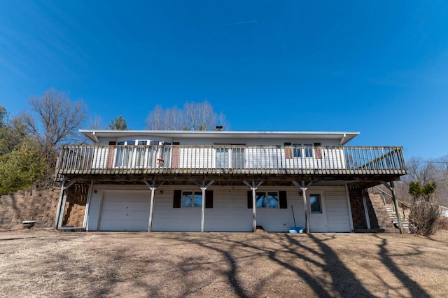 view of front facade featuring an attached garage, a deck, and stairs