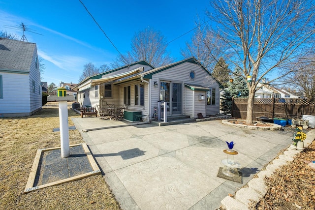 rear view of house with a patio, central AC unit, and fence