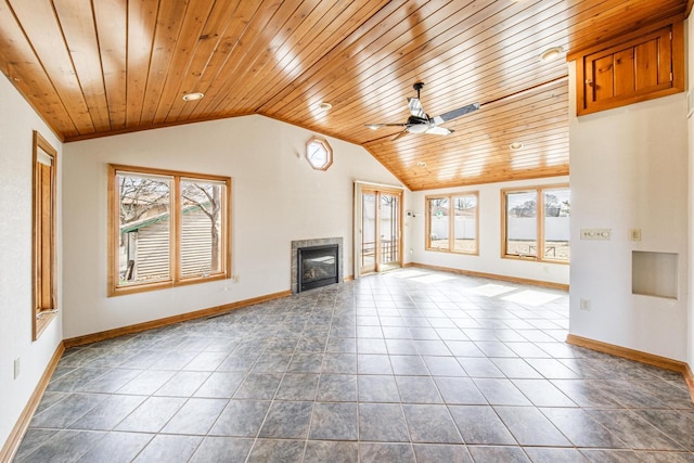 unfurnished living room featuring vaulted ceiling, a ceiling fan, a wealth of natural light, and a tile fireplace