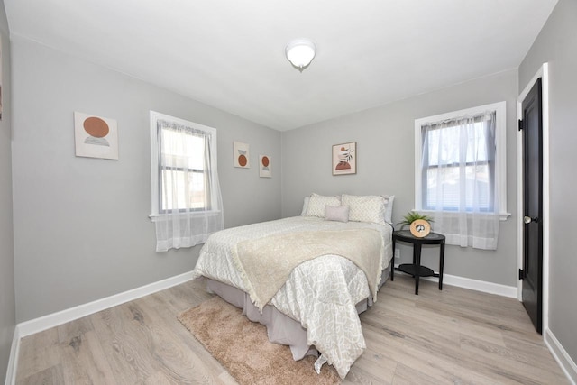 bedroom with baseboards and light wood finished floors