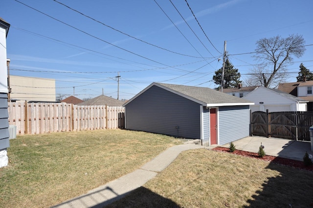 view of yard with an outdoor structure, a gate, fence, and a detached garage