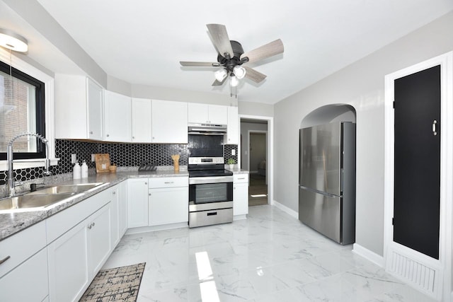 kitchen with a sink, decorative backsplash, stainless steel appliances, under cabinet range hood, and marble finish floor