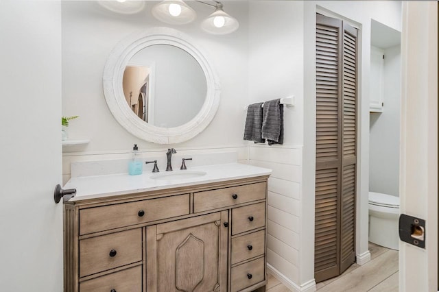 bathroom with vanity, toilet, and a closet