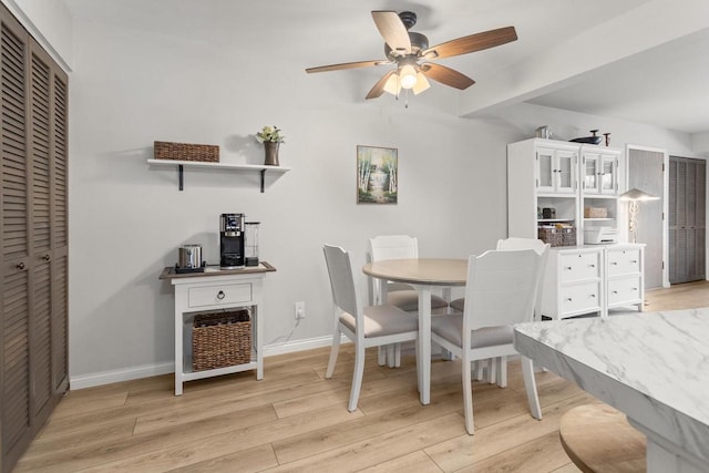 dining room with a ceiling fan, baseboards, and light wood finished floors