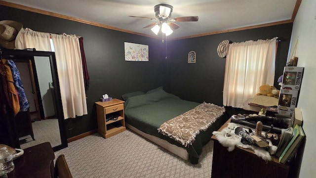 carpeted bedroom with a ceiling fan, baseboards, and ornamental molding