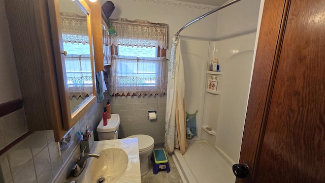 full bathroom with a stall shower, toilet, tile walls, and a sink