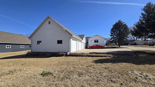 view of home's exterior featuring a lawn, concrete driveway, and an attached garage