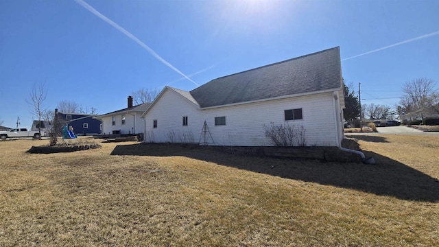 rear view of house featuring a yard