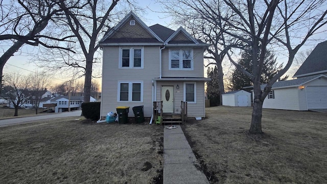 view of front of house with a yard, a garage, and an outdoor structure