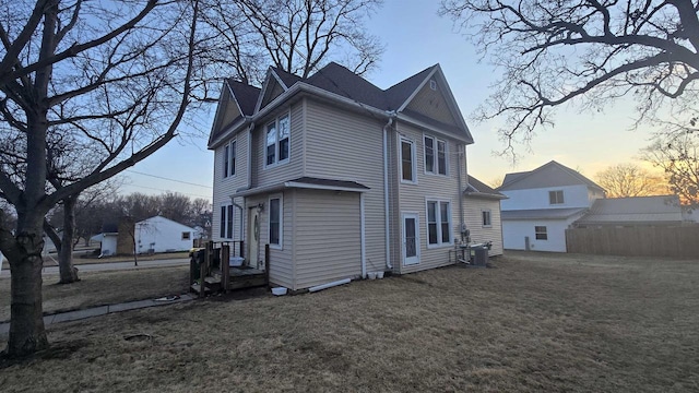 rear view of property with a yard, central AC, and fence