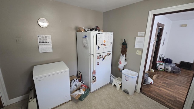 kitchen with baseboards, freestanding refrigerator, and white fridge